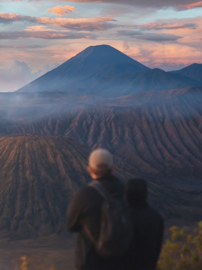 a couple of people standing on top of a mountain