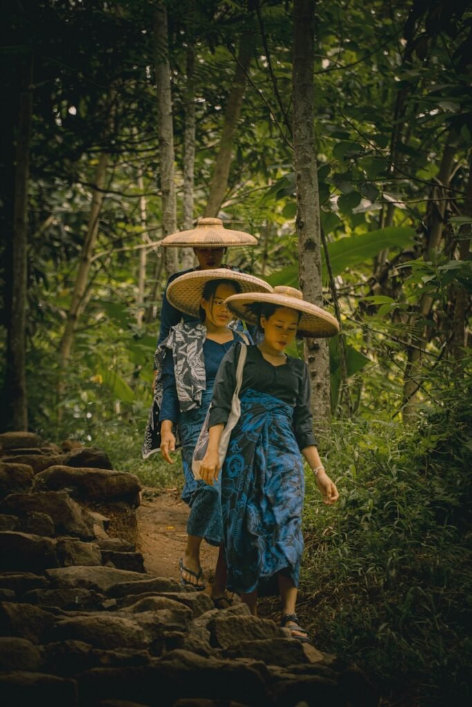 A couple of people walking down a dirt road