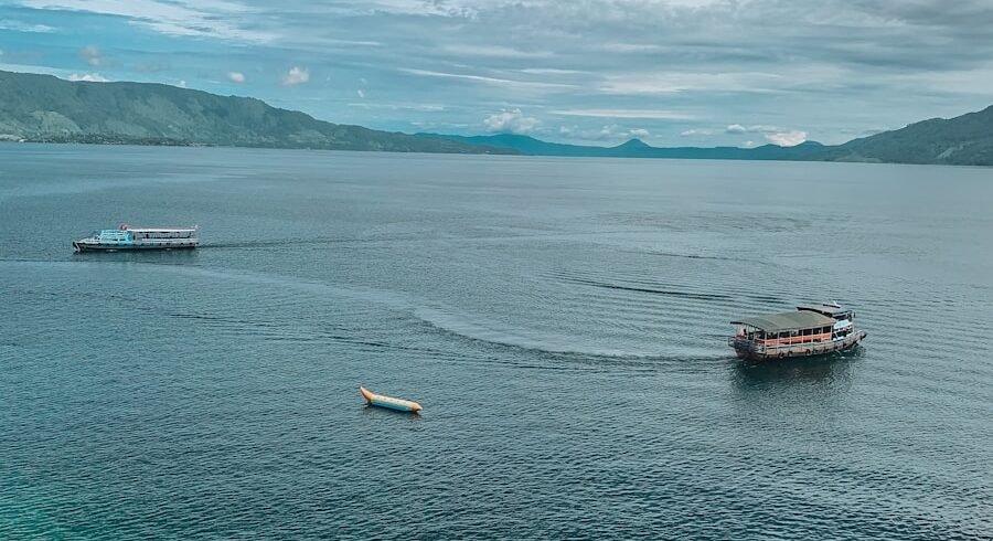 red and white boat on sea under blue sky during daytime