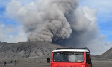red suv on brown sand under white clouds and blue sky during daytime