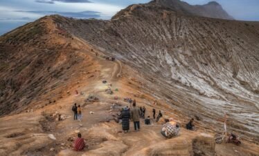 people walking on rocky mountain under blue sky during daytime