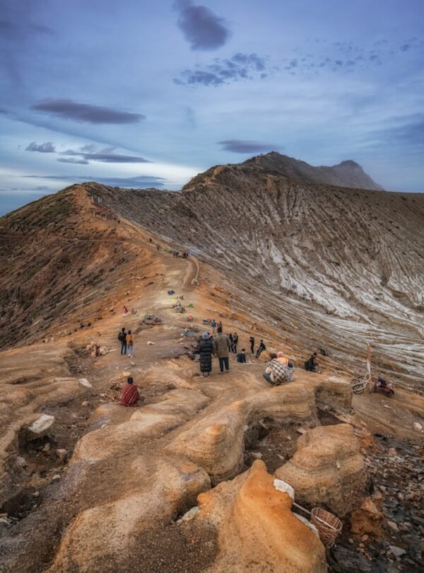 people walking on rocky mountain under blue sky during daytime