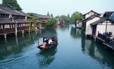 black boat on river near houses during daytime