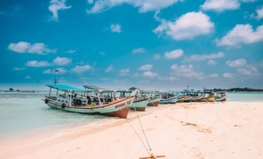 assorted-color boats on seashore during daytime