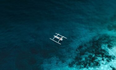 white and brown wooden boat on blue sea water during daytime