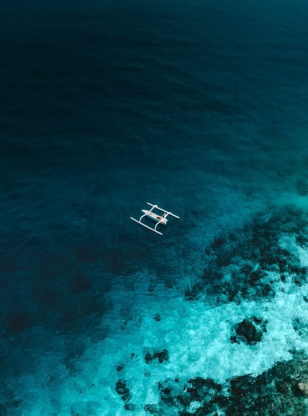 white and brown wooden boat on blue sea water during daytime