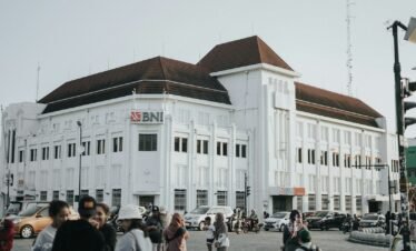a large white building with a lot of people walking around it