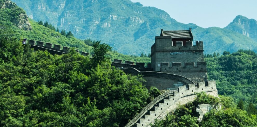 gray concrete building near green trees and mountain during daytime
